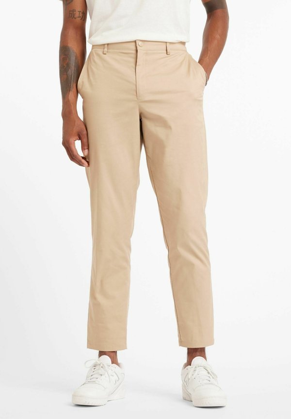 New Balance ATHLETICS STANDARD TAPERED PANT 30" - Chinos - beige