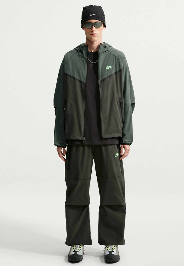 Nike Sportswear M NK DF TCH WVN WR FZ JKT - Summer jacket - newsprint camo green illusion green