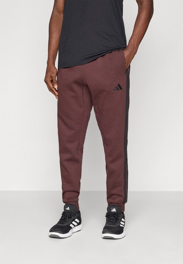 adidas Sportswear REGULAR FIT - Tracksuit bottoms - shadow brown/black