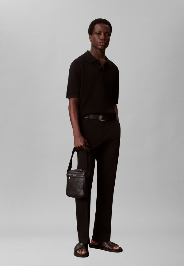 Calvin Klein EMBLEM AOP EMBOSS REPORTER - Cross body bag - black